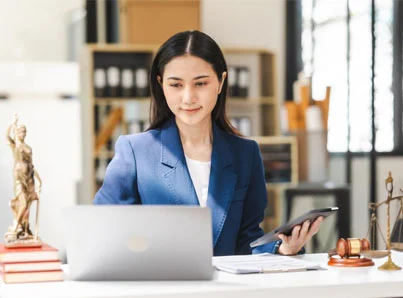 asian woman in business attire on laptop and smartphone