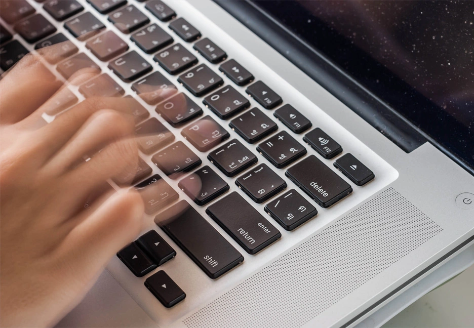 hands rapidly typing on laptop